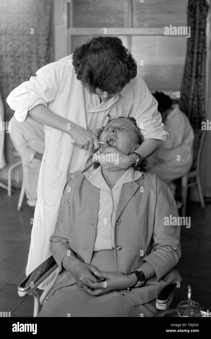 Tener una mujer de edad avanzada, la extracción del diente por un dentista hospital 1950 Hungría Foto de stock