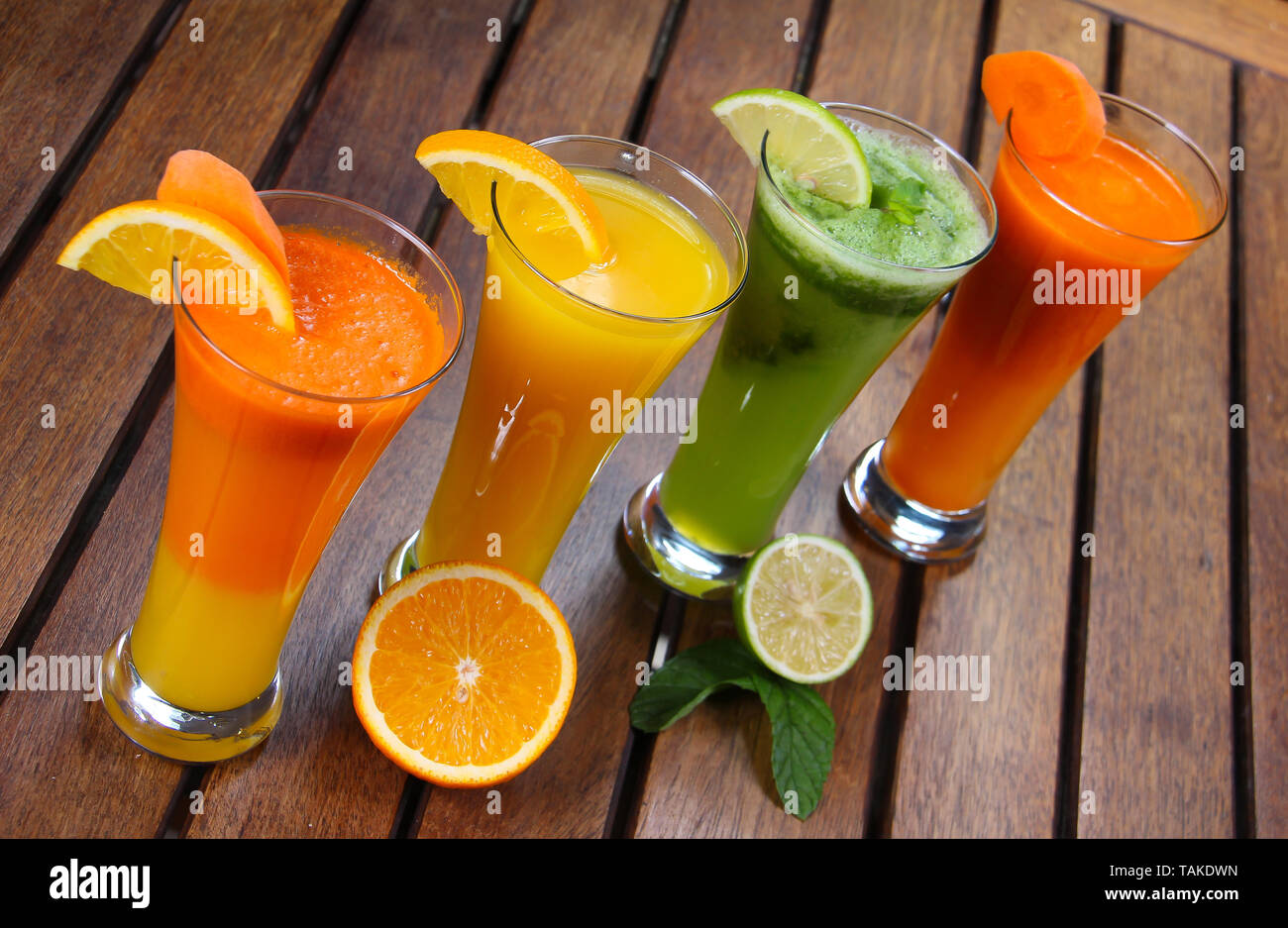 Vista superior de 4 largos vasos de jugos frescos y naturales: Naranja y  zanahoria, Naranja, Limón, menta, zanahorias Fotografía de stock - Alamy