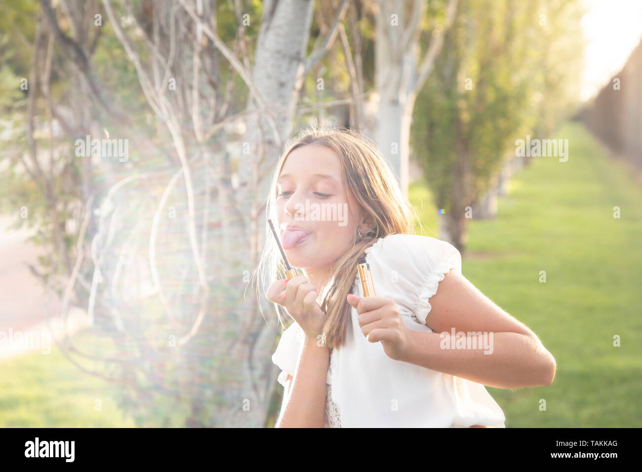 Un 13-year-old girl chistes con cepillo para pestañas Foto de stock