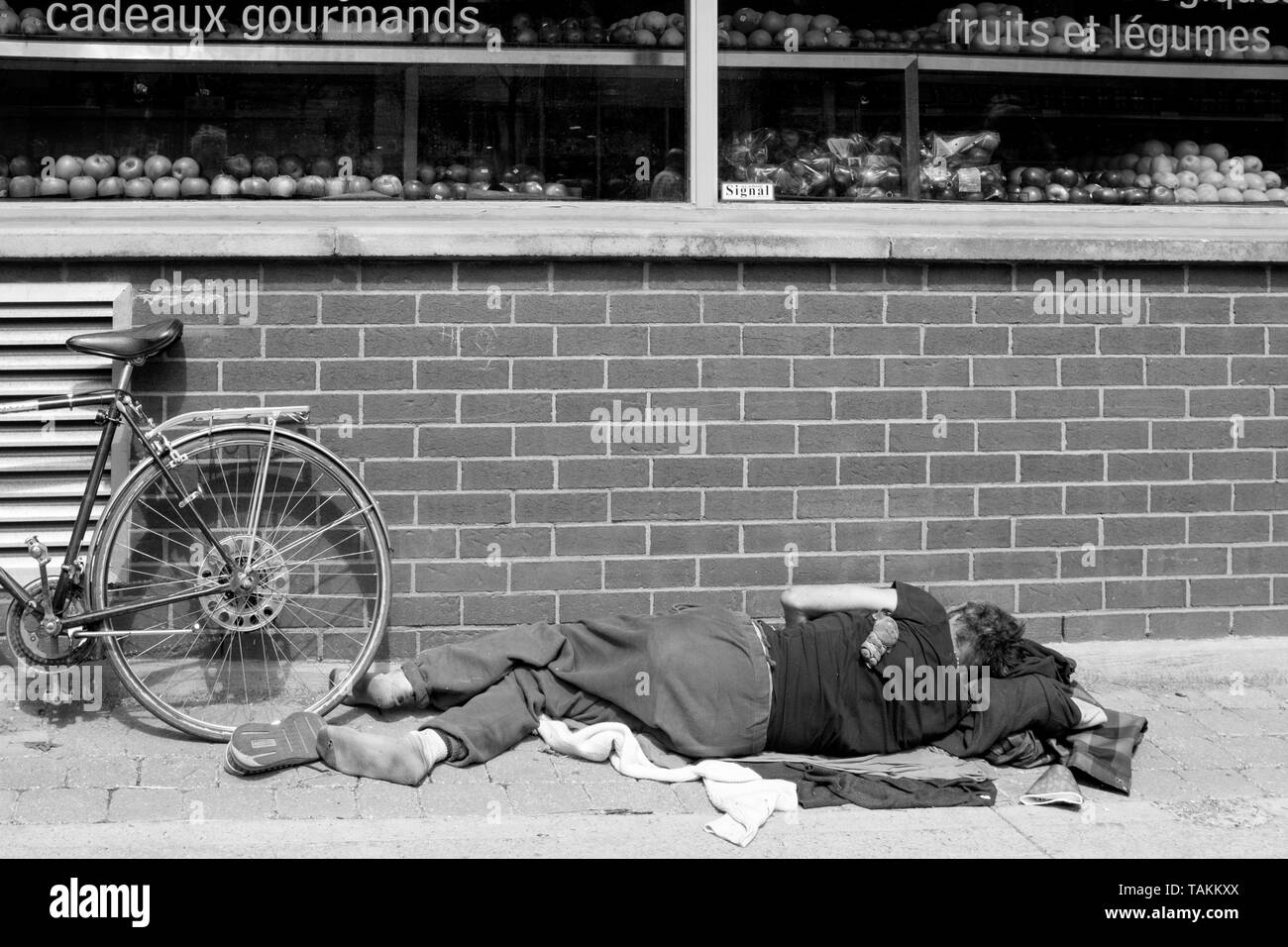 Persona sin hogar durmiendo en el suelo en una acera, Montreal, Canadá Foto de stock