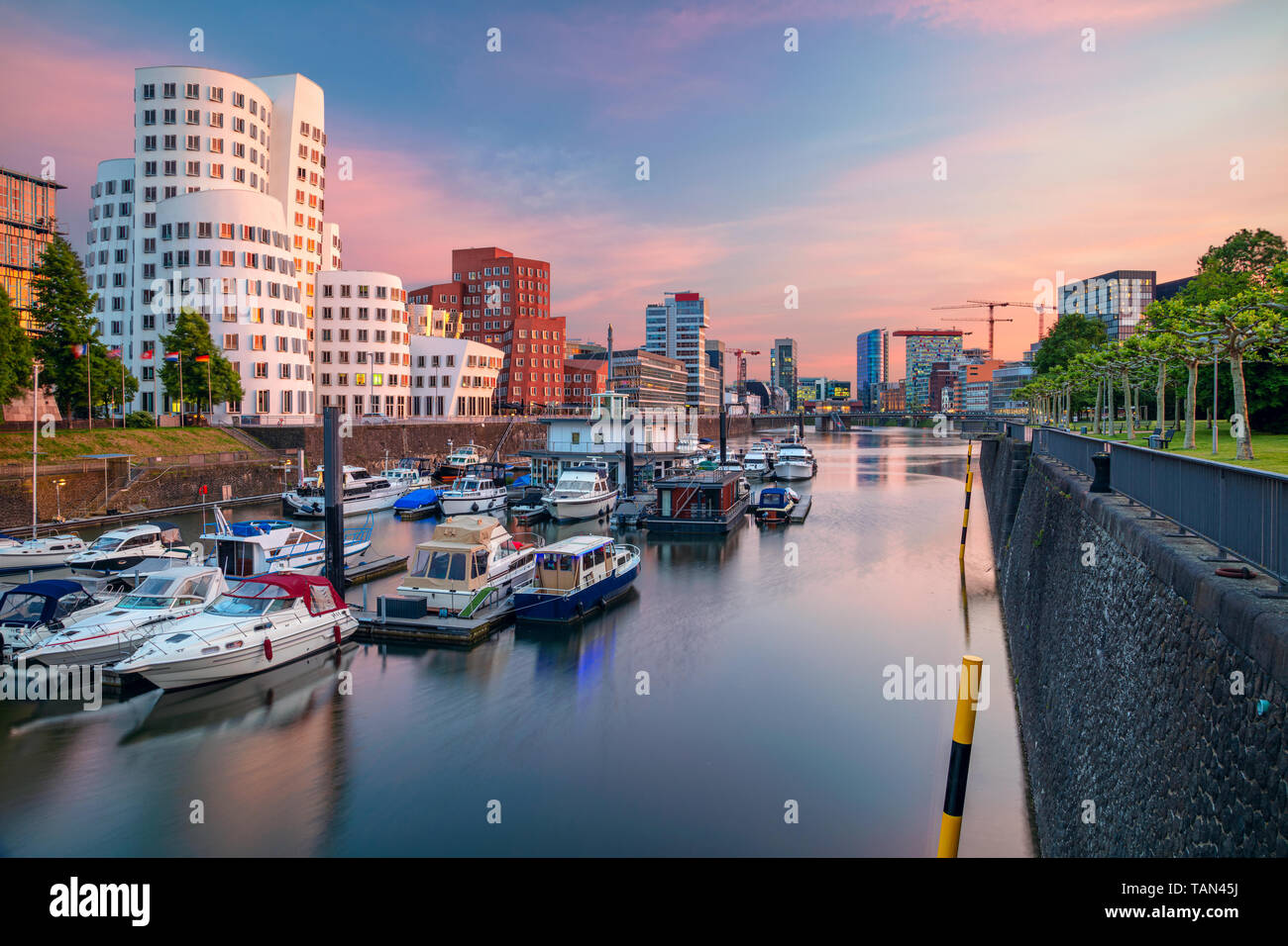 Düsseldorf, Alemania. Imagen de paisaje urbano de Düsseldorf, Alemania con el puerto de los medios de comunicación y el reflejo de la ciudad en el río Rin, durante la puesta de sol. Foto de stock