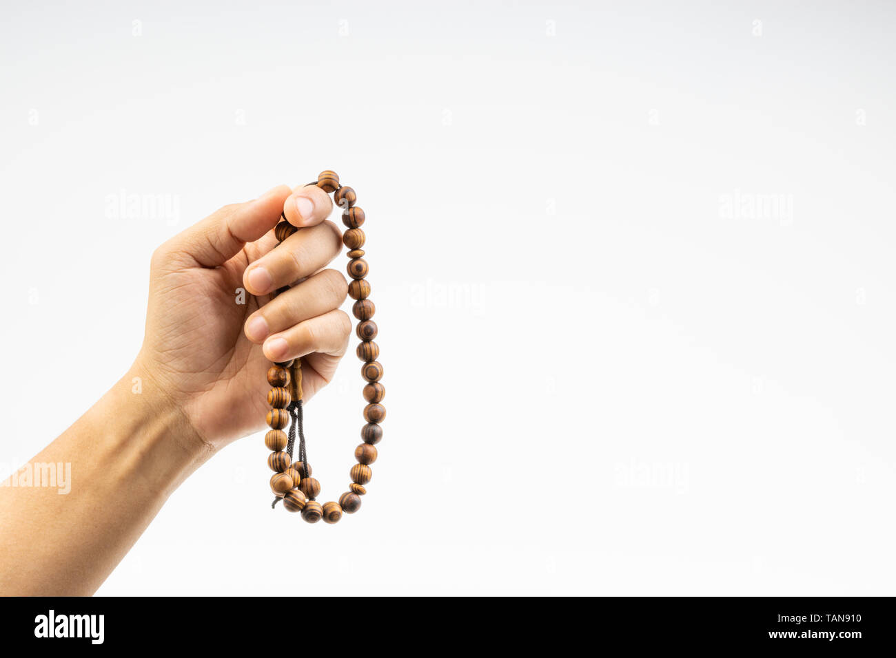 Mano sujetando un rosario o Tasbih musulmán sobre fondo blanco. Copie el  espacio y el enfoque selectivo Fotografía de stock - Alamy