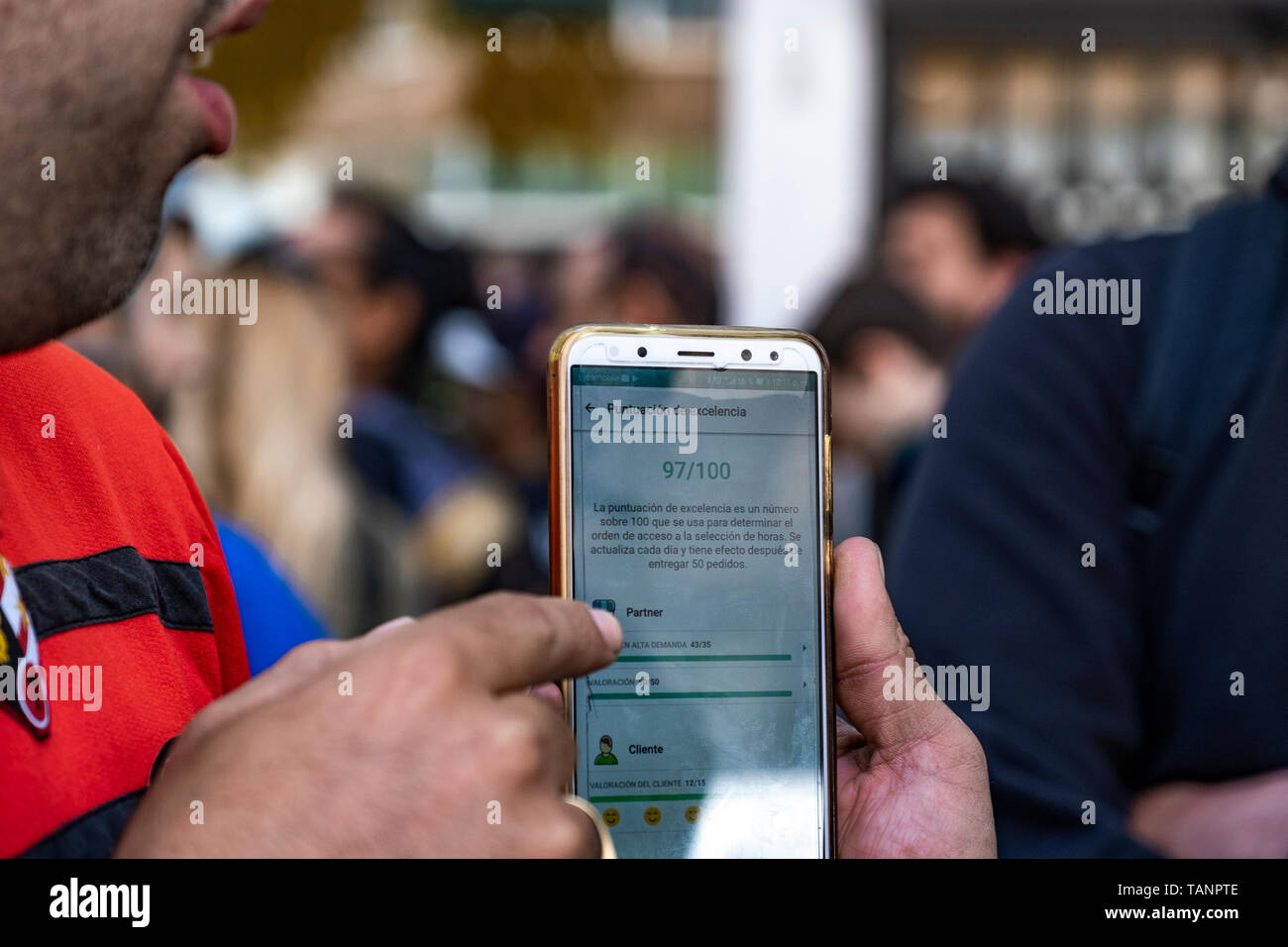 Un trabajador autónomo de la de entrega Glovo es visto mostrando una app con un puntaje de excelencia les permite acceder a la orden de acceso a la selección de