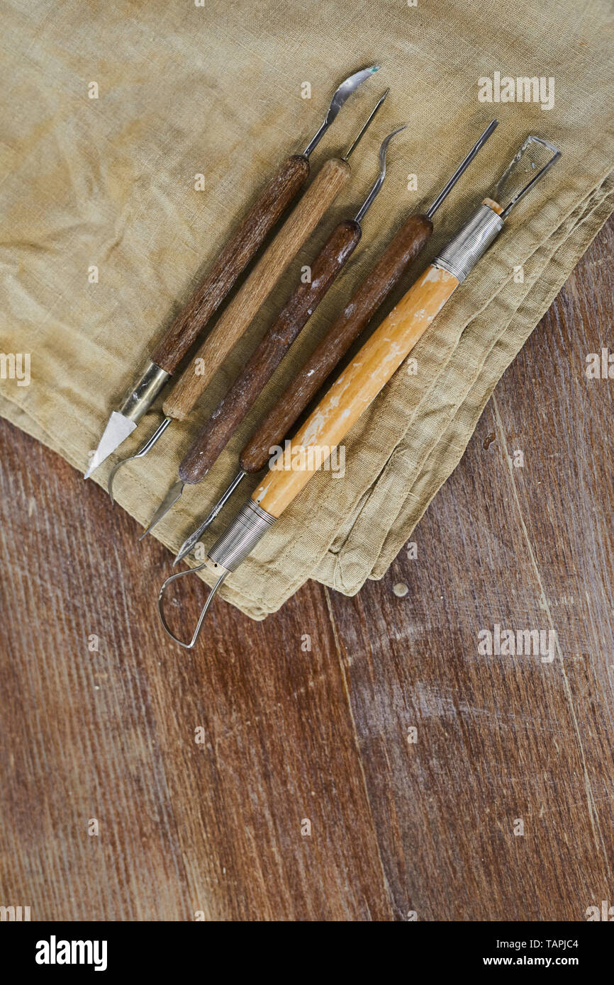 Close-up de diversas herramientas para esculpir para modelado de arcilla en  una servilleta sucia colocado sobre la mesa de madera Fotografía de stock -  Alamy