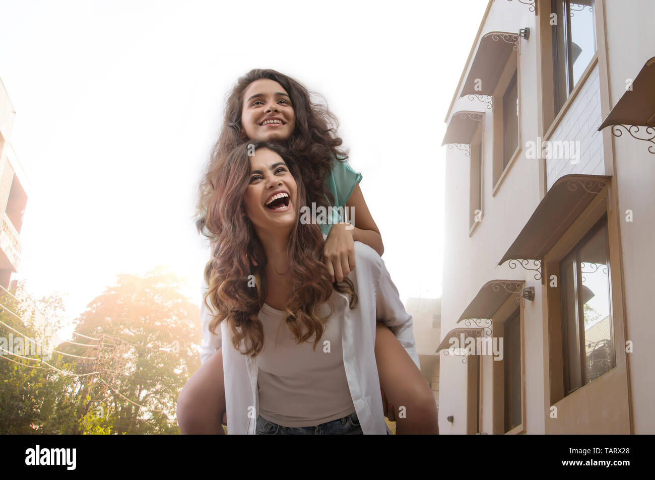 Mujer divirtiéndose llevando un amigo sobre su espalda Foto de stock
