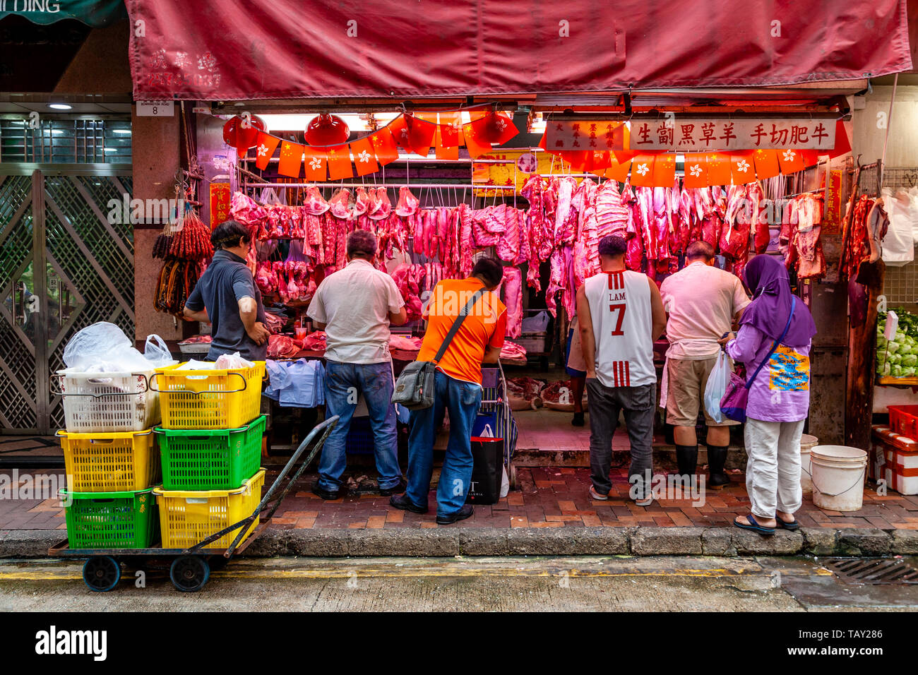 La gente local comprando carne a los carniceros Shop en el mercado alimentario Bowrington Road, Hong Kong, China Foto de stock