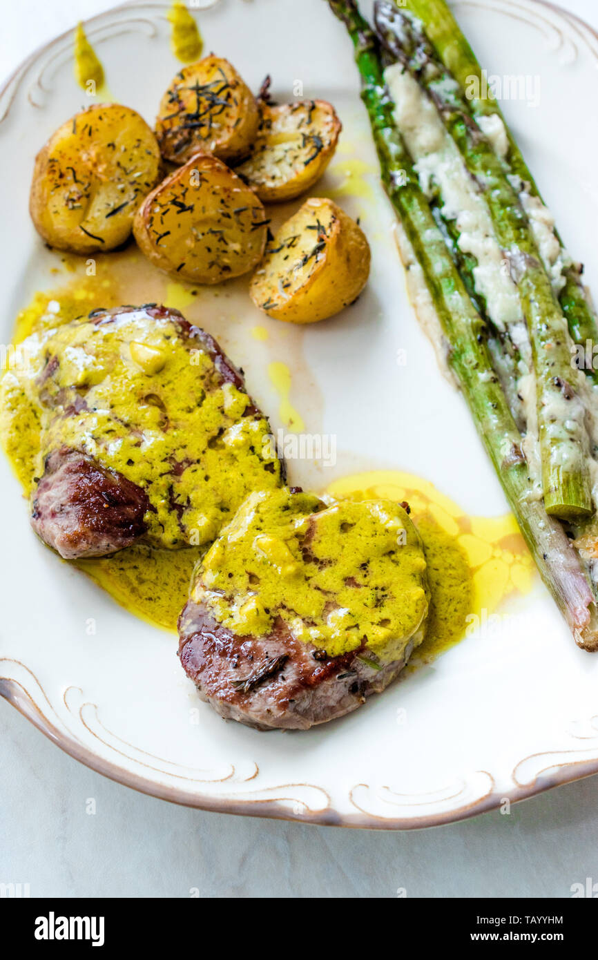 Carne de lomo con salsa Café de París con espárragos y patatas al horno en  la placa ya está listo para servir. Comida tradicional Fotografía de stock  - Alamy