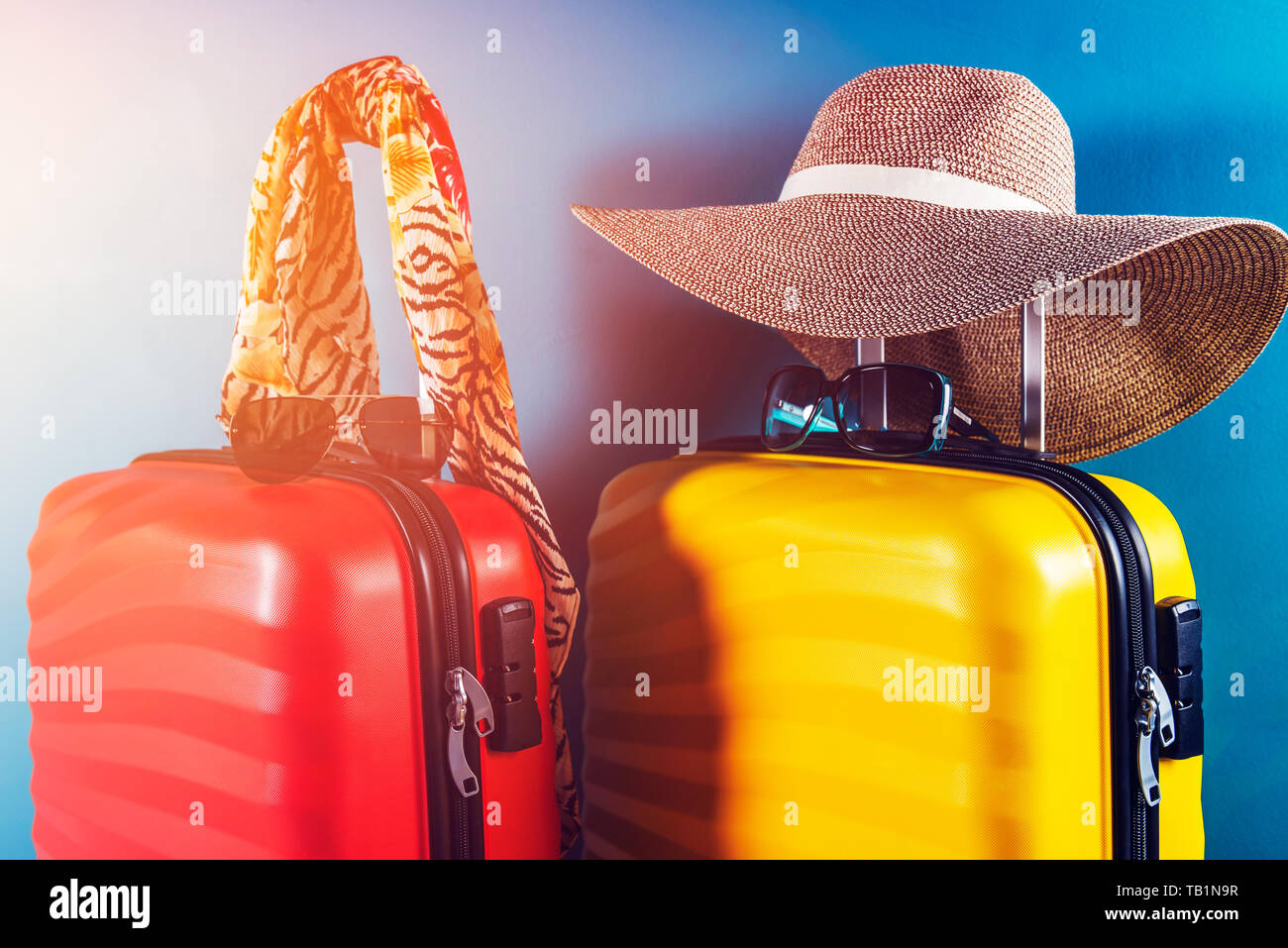 Luminosas y elegantes, tamaño de la cabina maletas y accesorios como  concepto de vacaciones contra fondo azul oscuro, copie el espacio. Viajar  con poco equipaje Fotografía de stock - Alamy