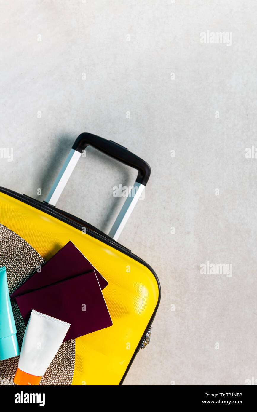 Luminoso y elegante cabina tamaño maleta con sombrero de paja, protector  solar y pasaportes laicos plana. Viajar con poco equipaje concepto. Copie  el espacio Fotografía de stock - Alamy