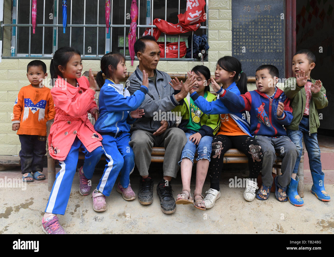 (190529) -- RONGSHUI, 29 de mayo de 2019 (Xinhua) -- Zhou Hongjun juega juegos con los estudiantes entre las clases en la escuela primaria en Xinhe Dayou aldea Miao Rongshui Condado Autónomo, sur de China, en la Región Autónoma de Guangxi Zhuang, 28 de mayo de 2019. Zhou Hongjun, un profesor de 46 años de experiencia, trabaja en una escuela desde que tenía 16 años en la remota zona rural en el condado de Rongshui autónoma Miao. Antes de 2010, no había carreteras de acceso a la escuela, todos los escolares fueron tomadas por Zhou llevando a sí mismo con un palo. Zhu, supuestamente para jubilarse en 2018, decidió continuar su carrera como no hay sustituto teac Foto de stock