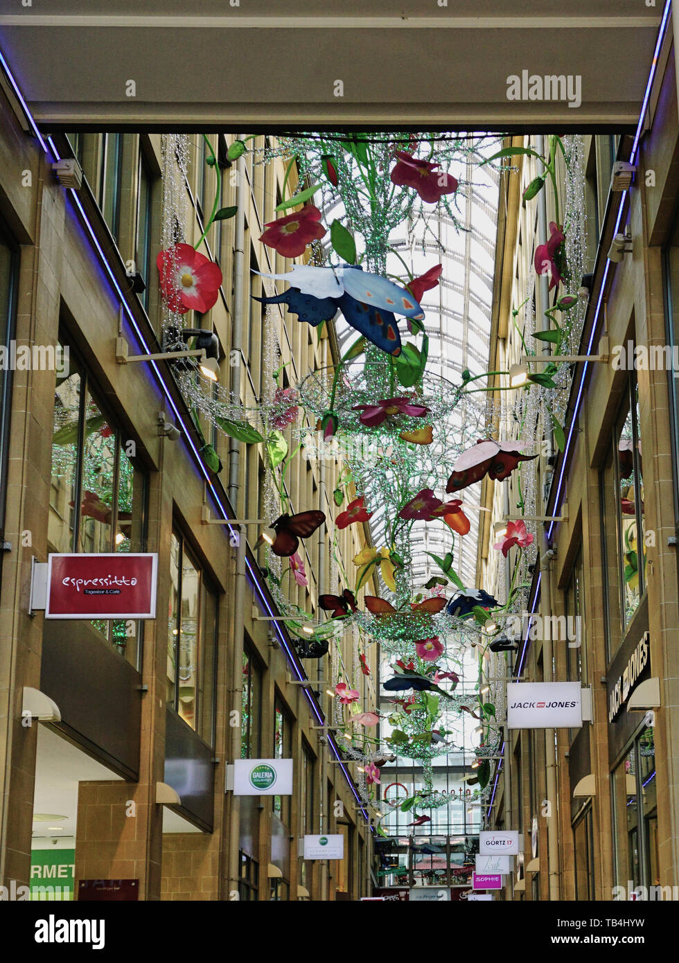 Muestra Arte de mariposas coloridas de móviles colgantes en cristal centro comercial techado en Alemania Fotografía stock -