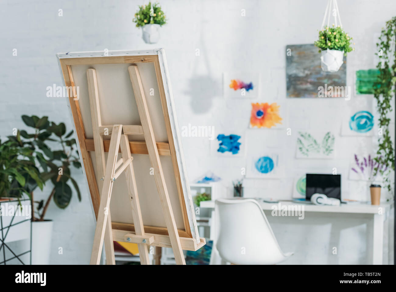 Habitación espaciosa con caballete, pinturas de pared y plantas en macetas  Fotografía de stock - Alamy