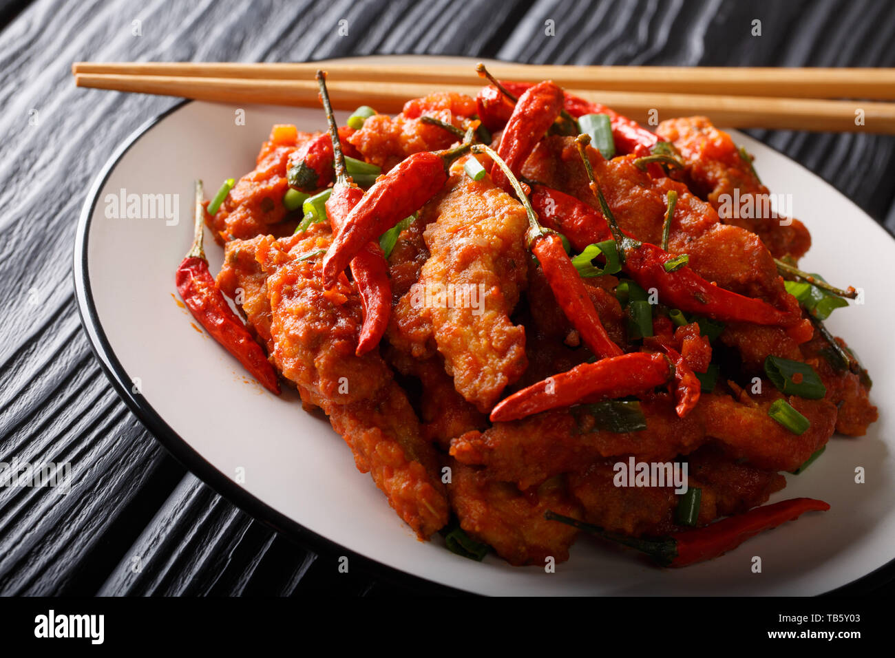 Szechuan chino pollo en salsa picante con ajo y ají de cerca en una placa  horizontal sobre la mesa Fotografía de stock - Alamy