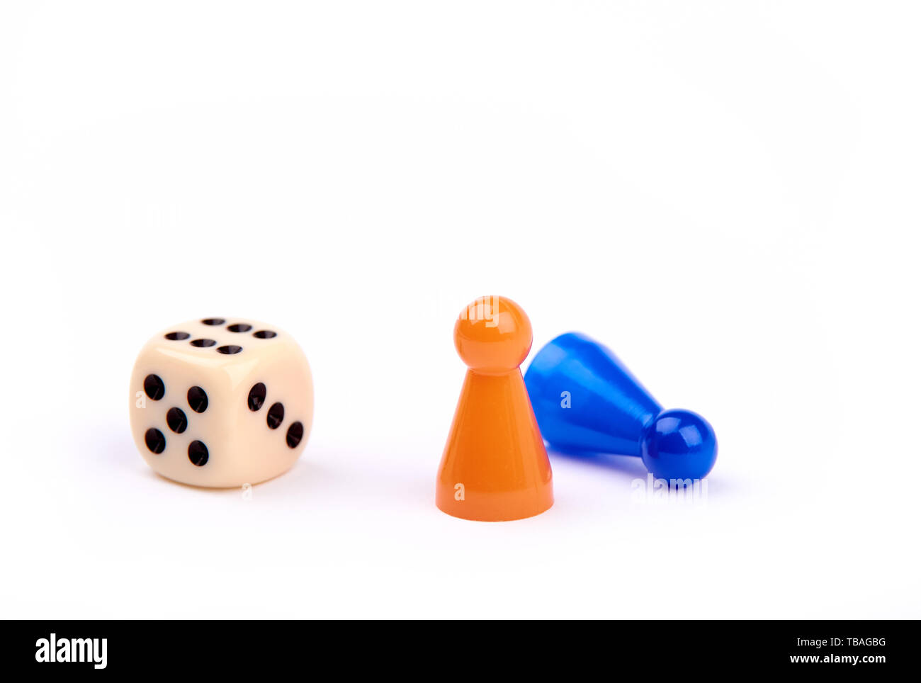Jugar a los dados con puntos negros y el número seis, dos piezas de juego, naranja y azul como ganador permanente mintiendo como perdedor - aisladas sobre fondo blanco. Foto de stock