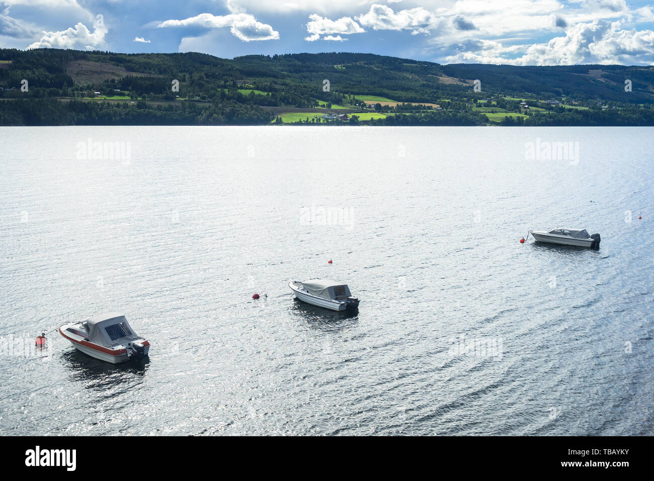 Tres barcos rodeado por el hermoso paisaje de verano lakeduring Mjosa, Hedmark, Noruega Foto de stock