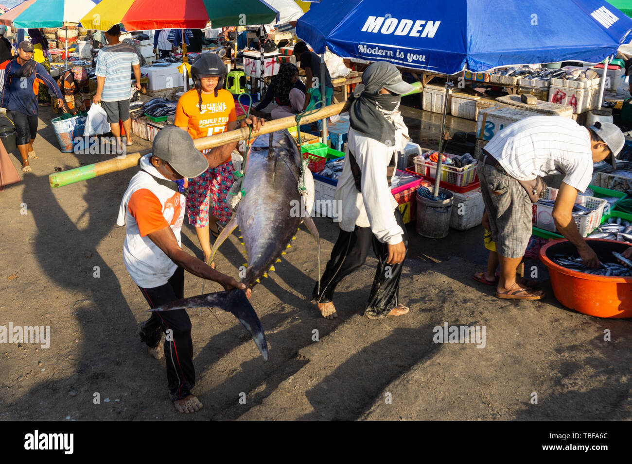 BALI/Indonesia el 15 de mayo de 2019: la atmósfera del mercado de pescado Kedonganan-Bali con coloridas sombrillas en cada quiosco. Algunos pescadores van a casa desde fishi Foto de stock