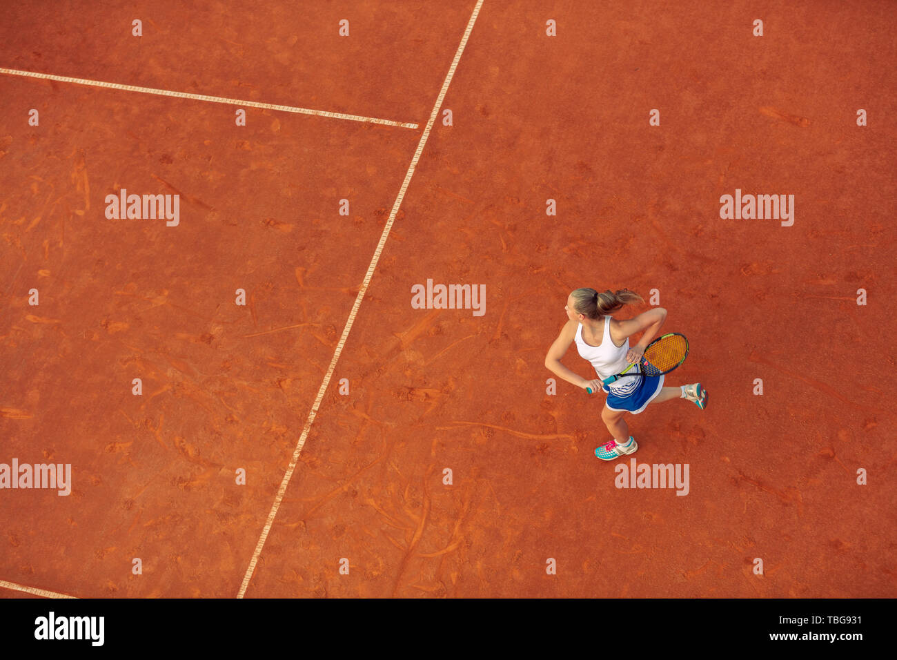 Toma aérea de un jugador de tenis femenino en un tribunal durante el partido. Chica jugando tenis.Un alto ángulo de visualización. Foto de stock