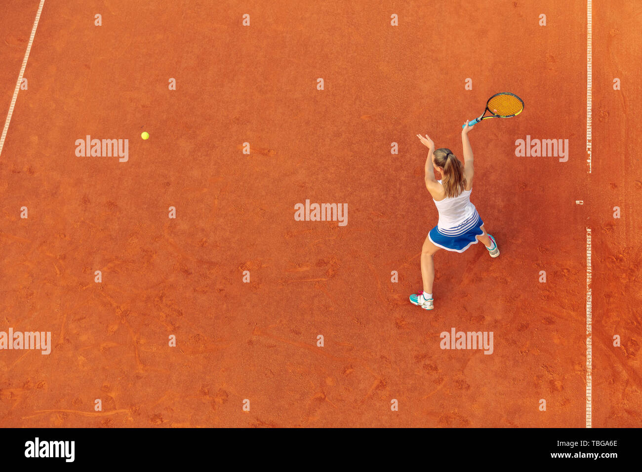 Toma aérea de un jugador de tenis femenino en un tribunal durante el partido. Chica jugando tenis.Un alto ángulo de visualización. Foto de stock