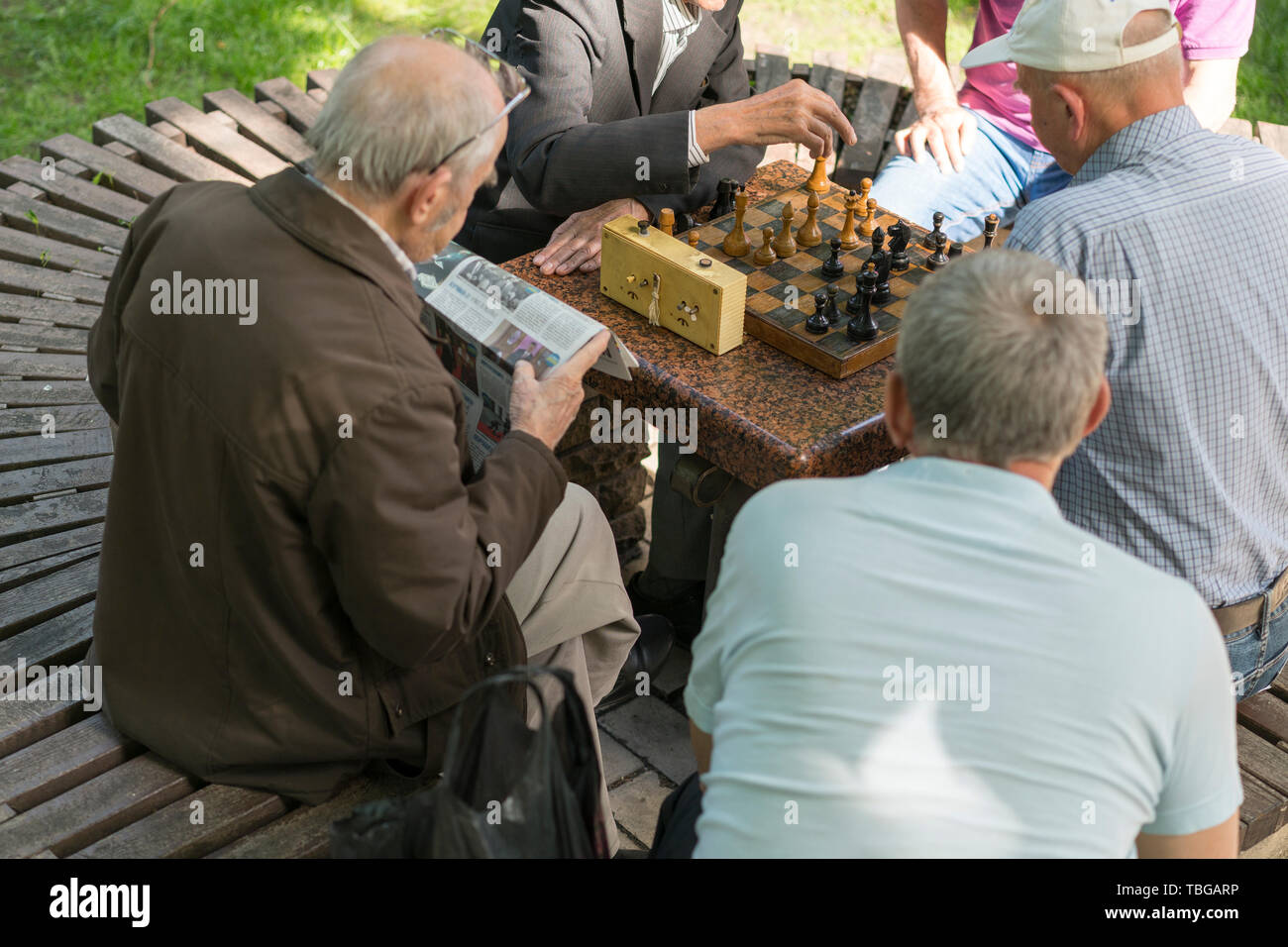 Active los jubilados, viejos amigos y el tiempo libre, los ancianos a  divertirse y jugar un juego de ajedrez en el parque. Cintura para arriba.  Viejos jugando al ajedrez en el parque