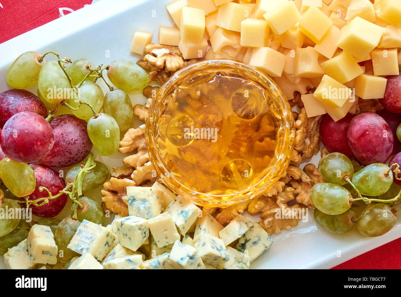 Diferentes tipos de queso, uvas, nueces y miel gourment surtido, ángulo superior Foto de stock