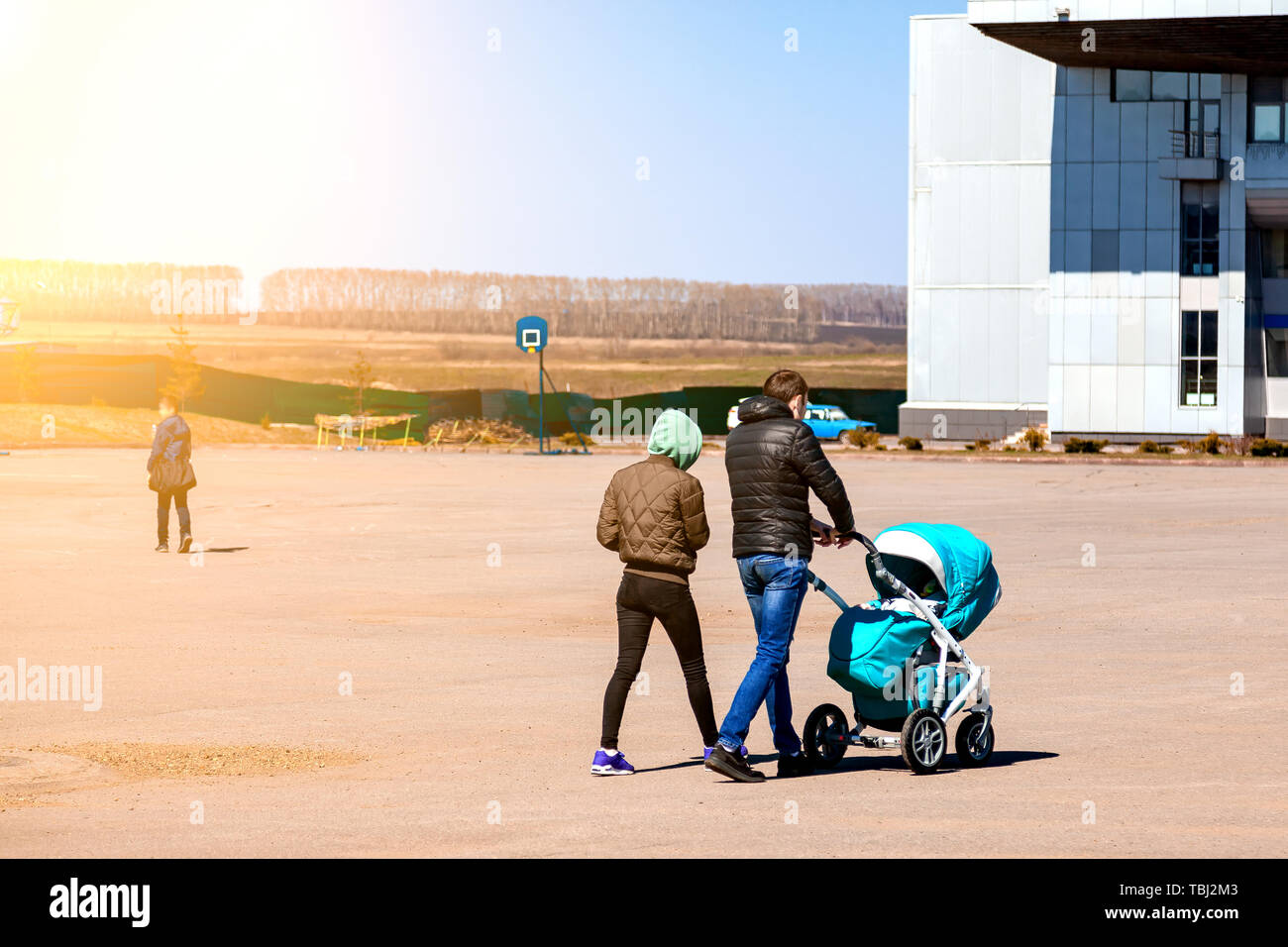 Familia Joven Pareja Con Mama Y Papa Estan Caminando Afuera Con Un Cochecito De Bebe De Color Azul En La Que El Recien Nacido En Una Gran Zona De La Ciudad En Familia Joven Pareja Con Mama Y Papa Estan Caminando Afuera Con Un Cochecito De Bebe De Color Azul En La Que El Recien Nacido En Una Gran Zona De La Ciudad En