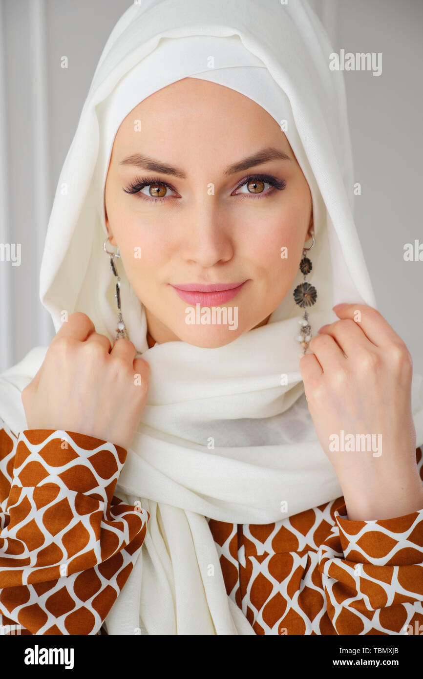 Retrato de joven y bella mujer árabe musulmanas vestidas de blanco pañuelo  mirando a la cámara, cerrar Fotografía de stock - Alamy