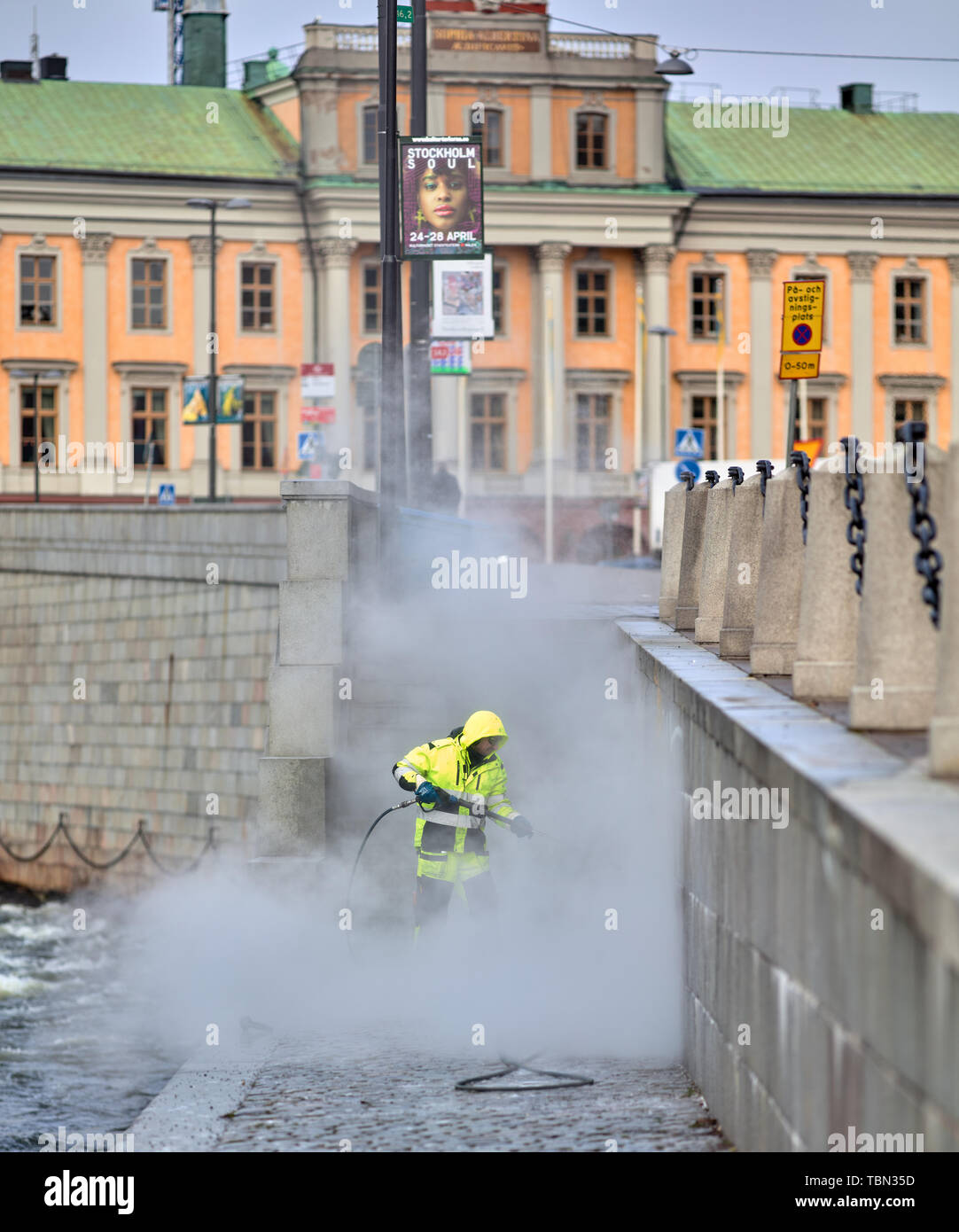 Limpieza de corriente de agua a alta presión en Strömgatan, centro de Estocolmo, Suecia Foto de stock