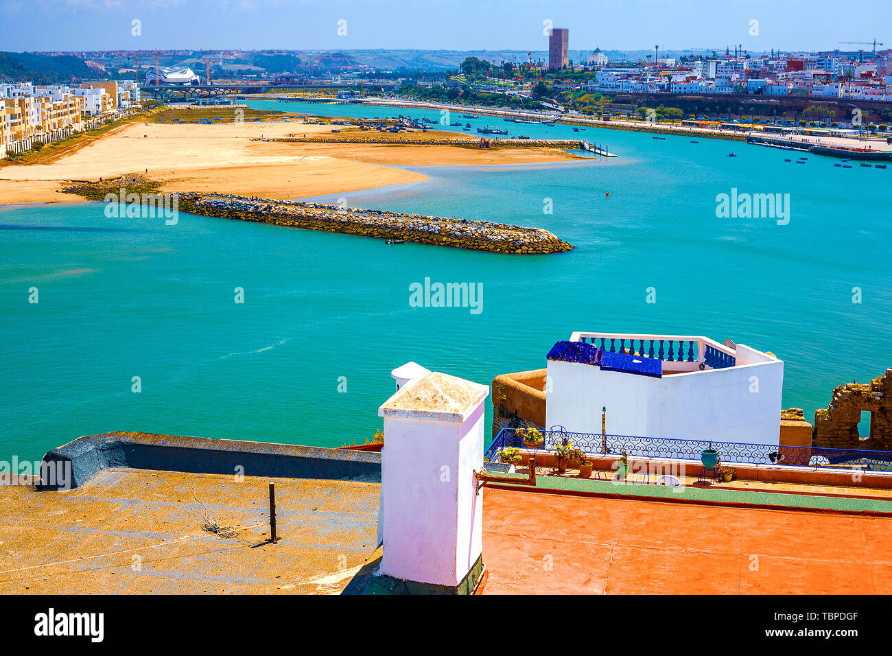 El techo de un edificio tradicional con una chimenea y un tubo con vistas al océano y a la costa en el distrito de Medina en la ciudad de Rabat, Moro Foto de stock