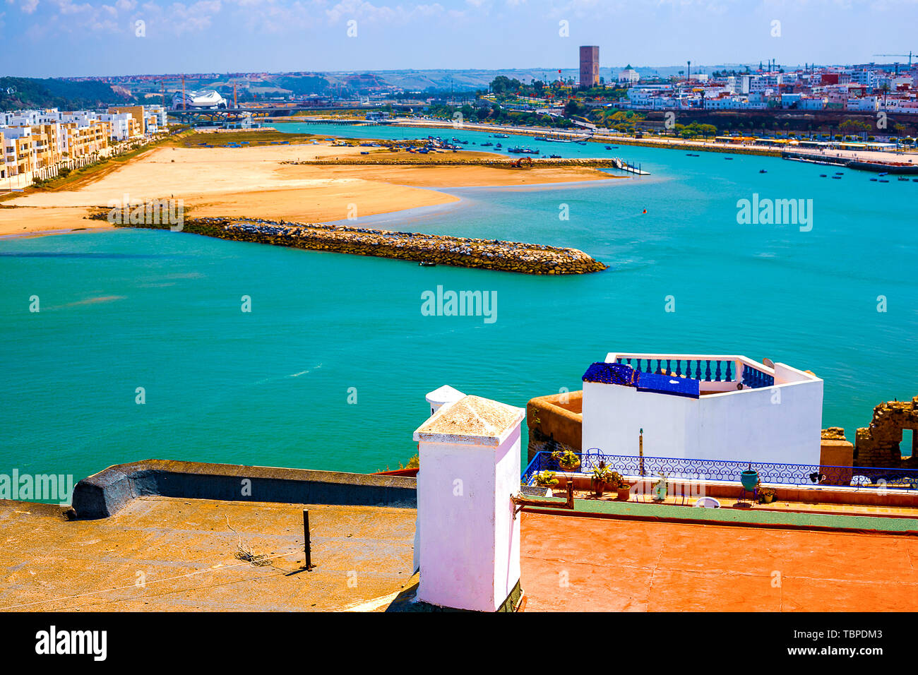 El techo de un edificio tradicional con una chimenea y un tubo con vistas al océano y a la costa en el distrito de Medina en la ciudad de Rabat, Moro Foto de stock