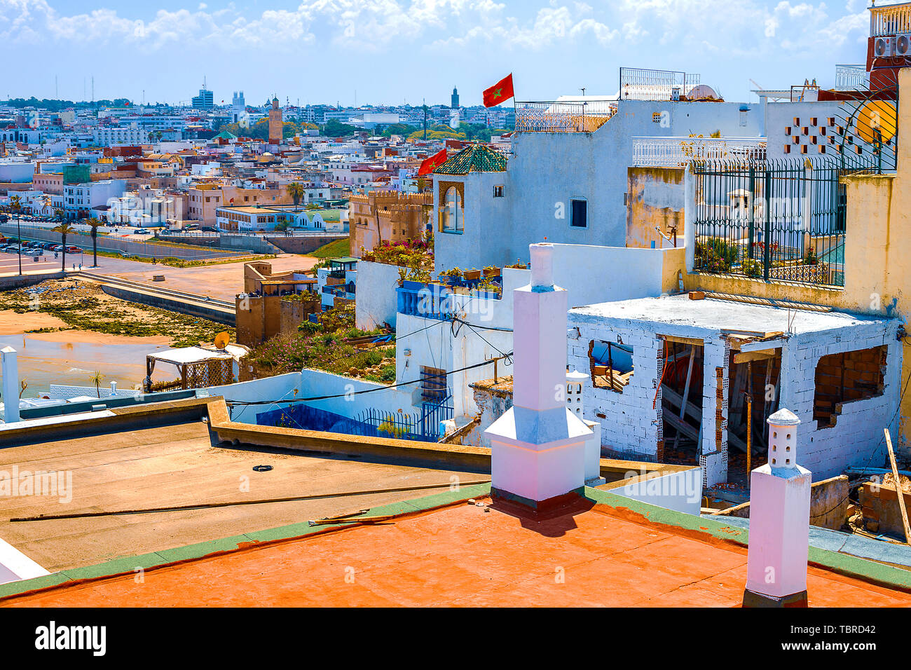 El techo de un edificio tradicional con una chimenea y un tubo con vistas al océano y a la costa en el distrito de Medina en la ciudad de Rabat, Moro Foto de stock