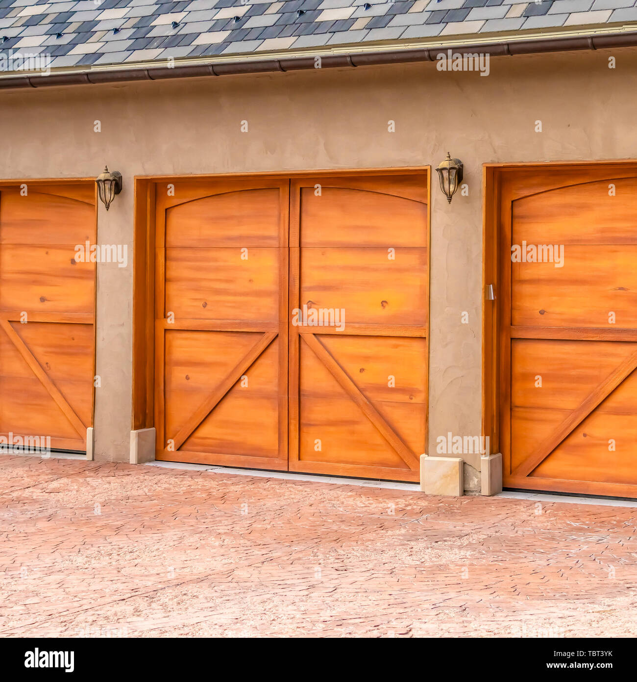 Bastidor Cuadrado exterior de una lujosa casa con elegantes puertas de  garaje de madera marrón Fotografía de stock - Alamy