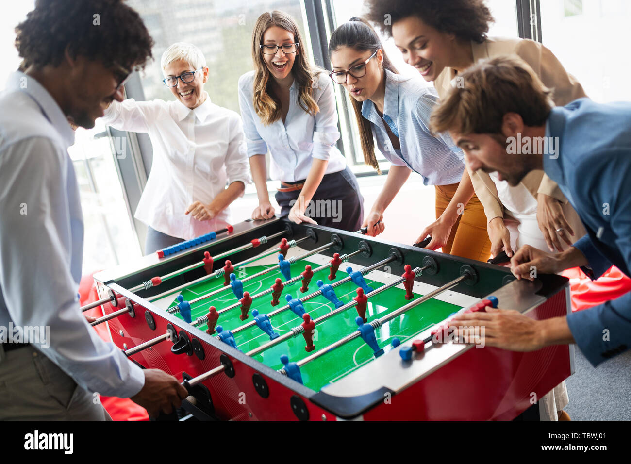 La gente de negocios con gran tiempo juntos.colegas jugando fútbol en la oficina. Foto de stock