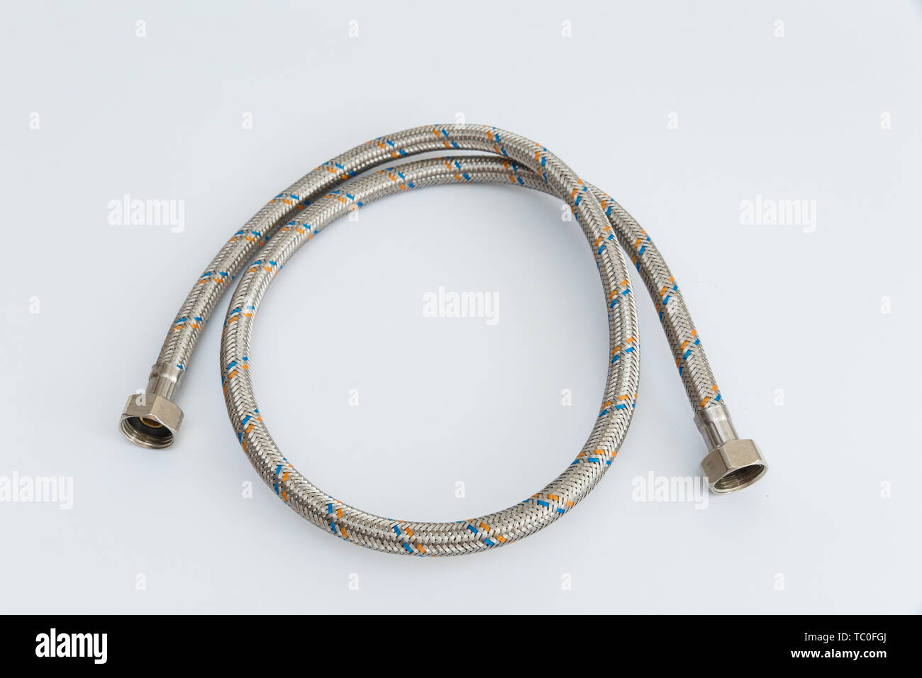 Tubo flexible para el agua en una malla de metal sobre un fondo blanco  Fotografía de stock - Alamy