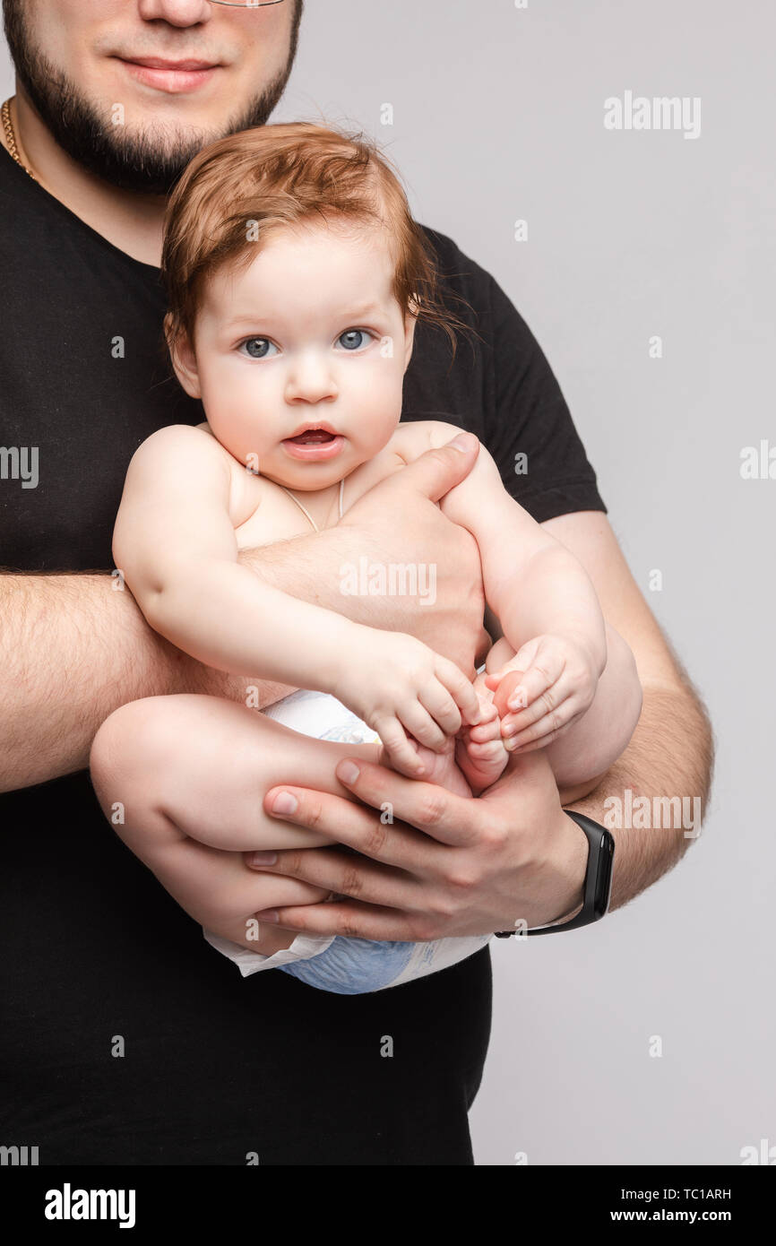 Padre mantener pequeño bebé en las manos y besarse kid Foto de stock