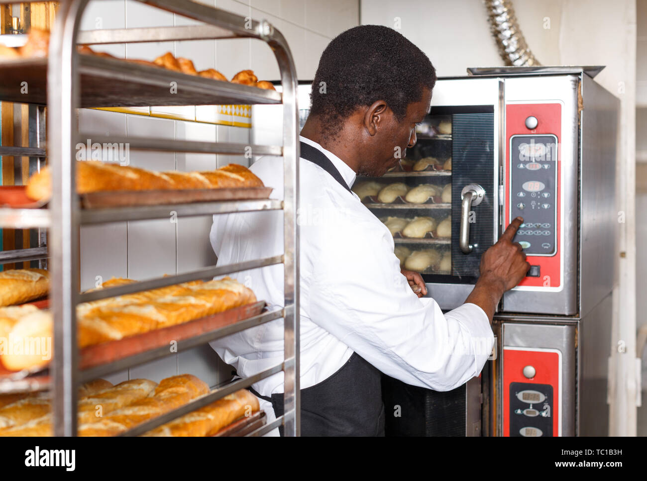 Experimentado baker controlando el proceso de cocción de pan, programación  profesional en la panadería de horno Fotografía de stock - Alamy