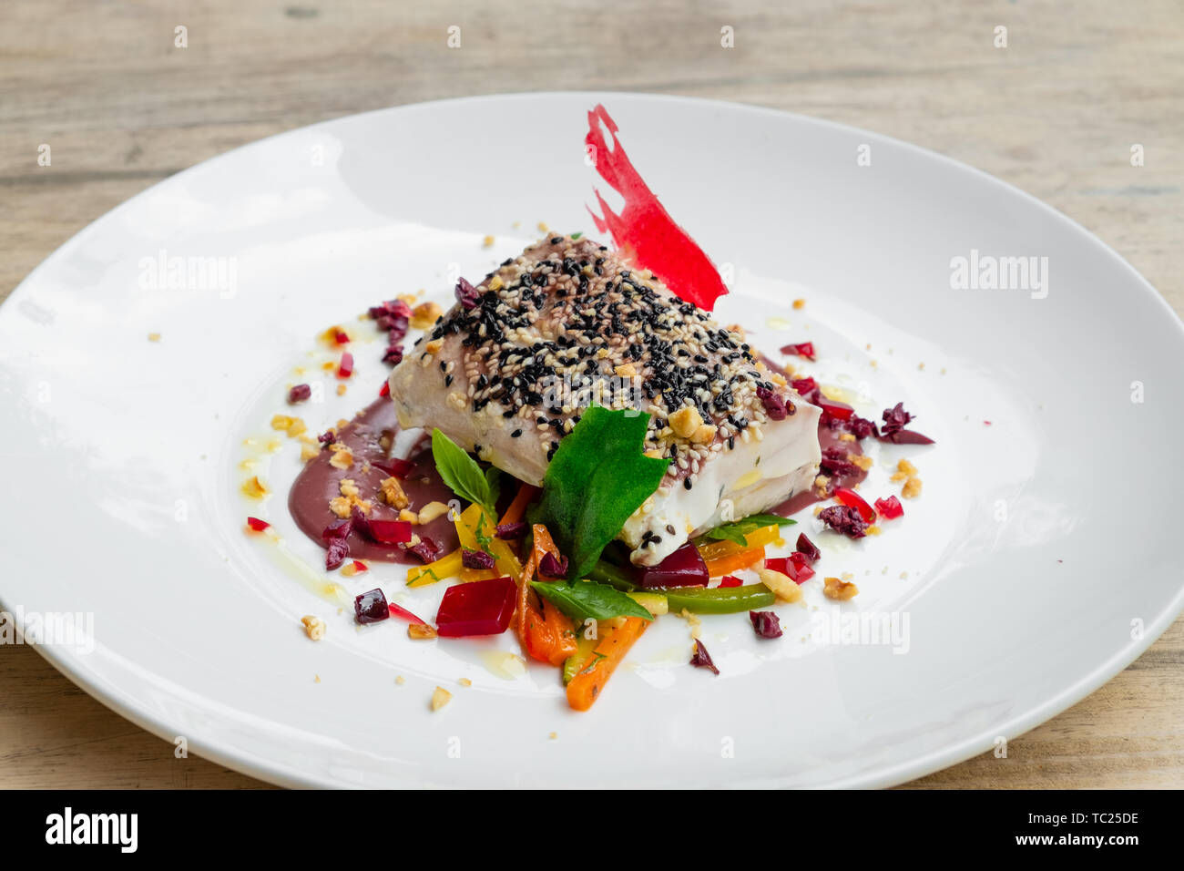 Cerca de cocinado lentamente SOUS VIDE de lomo de atún con costra de sésamo  blanco y negro de oliva, salsa de verduras mixtas gelatina de vino blanco,  luz natural placa FO Fotografía