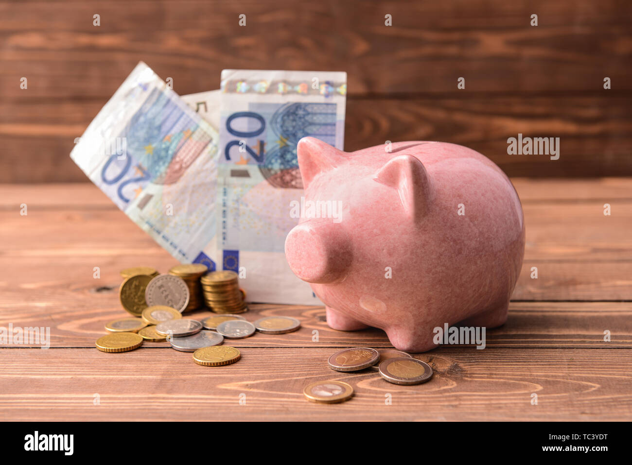 Los billetes y monedas en euros con hucha sobre mesa de madera. Concepto de  ahorro de dinero Fotografía de stock - Alamy