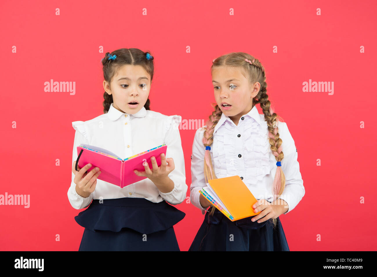 La lectura abre puertas. Los niños pequeños leyendo libros sobre fondo  rojo. Adorable pequeño niñas aprender a leer en la escuela. Cute alumnos  leyendo para saber información importante Fotografía de stock -