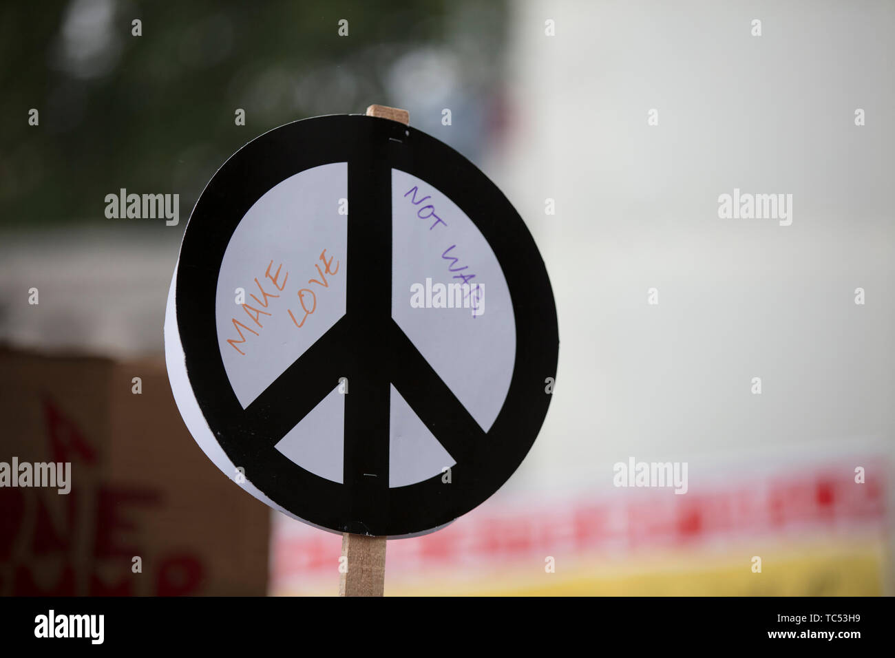 Una persona tiene un signo de paz banner en una protesta Foto de stock