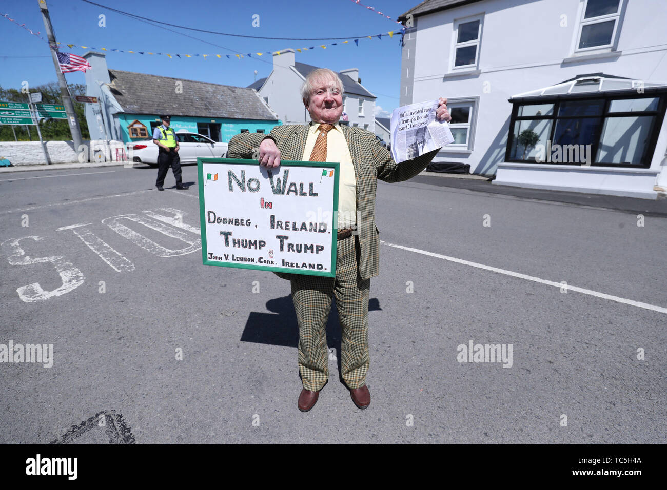 Anti Donald Trump manifestante John Lennon sostiene un cartel en la aldea de Doonbeg en Co Clare como una gran operación de seguridad entra en funcionamiento para la llegada del presidente de Estados Unidos. Foto de stock