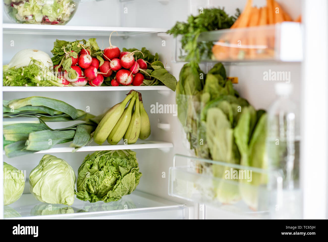 Refrigerador doméstico lleno de verduras y frutas frescas, zanahoria, nabo,  col, lechuga, plátanos, etc Fotografía de stock - Alamy