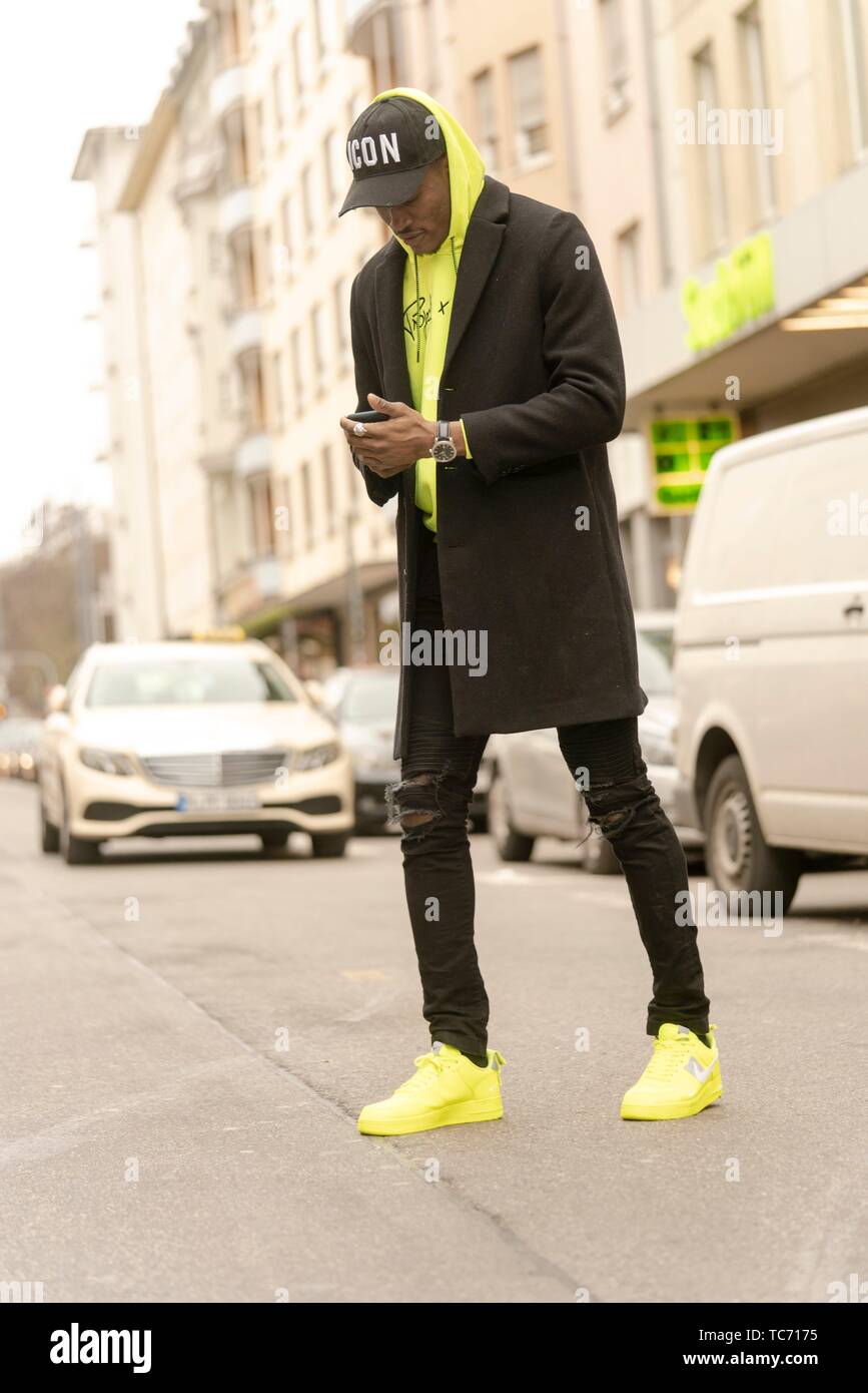 Hombre elegante en la calle con el smartphone en las manos, ropa de estilo urbano, la ropa de los blogger, Munich, Fotografía de stock -