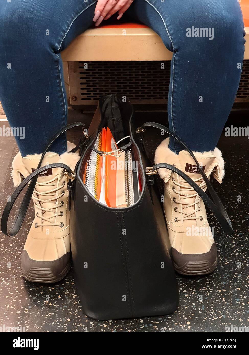 Mujer de manos con largas uñas postizas llevar botas de fantasía con una  bolsa llena de libros. El metro de Nueva York. NY. EE.UU Fotografía de  stock - Alamy