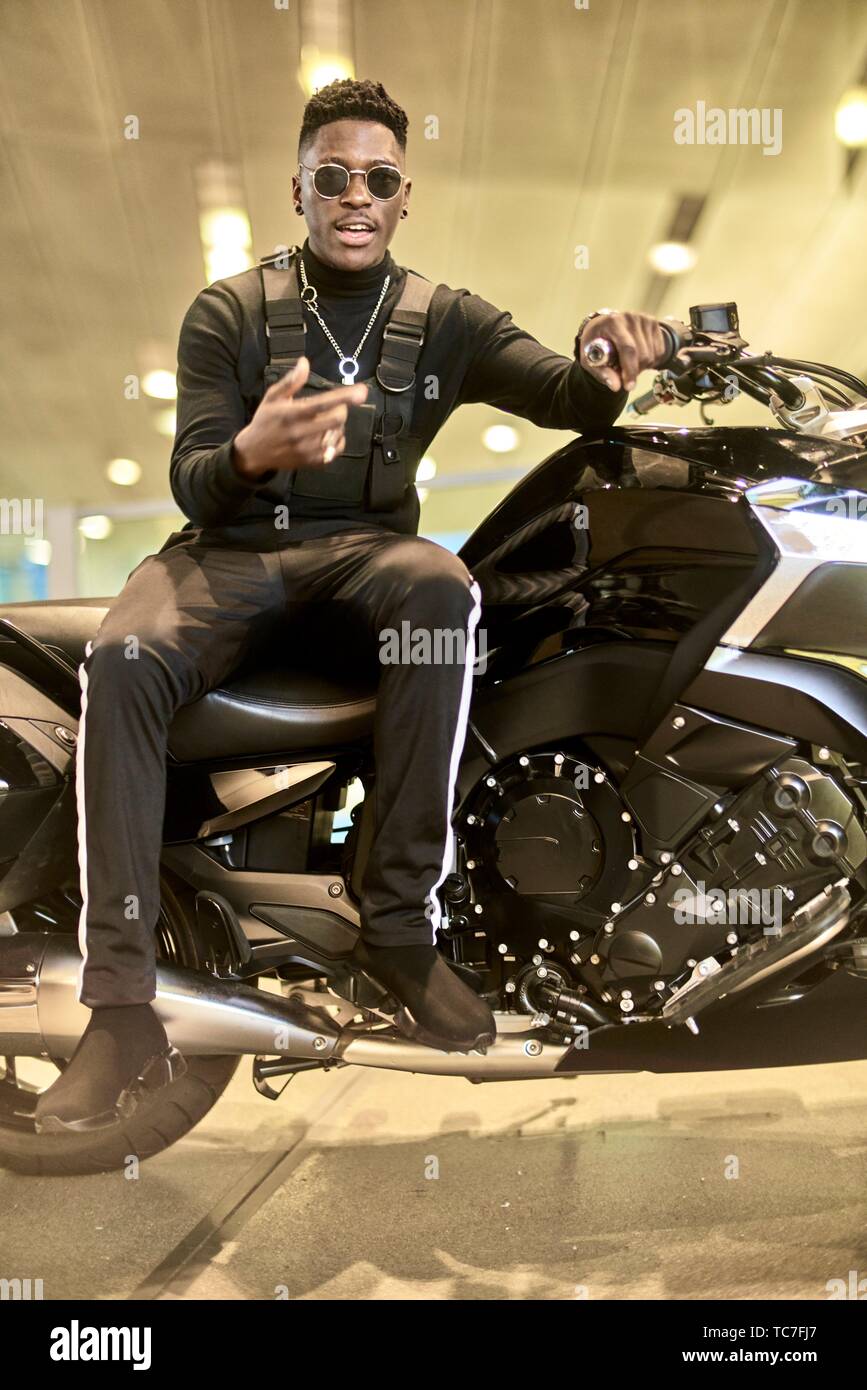 Moda hombre sentado en moto Fotografía de stock - Alamy