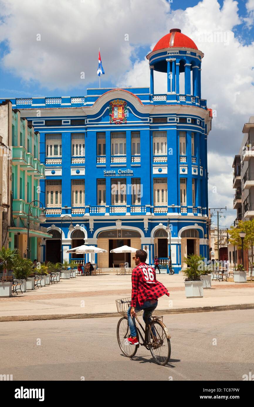 Ciclista en frente de la Santa Cecilia Convención Center-Centro de Convenciones, en el centro histórico de la ciudad, Camagüey, Cuba, Las Antillas, América Central Foto de stock