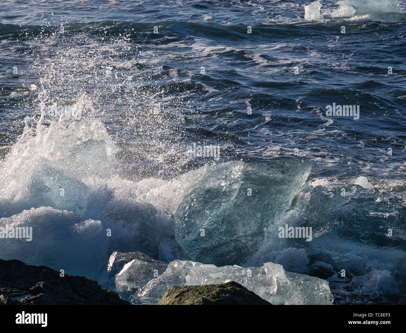 Las olas rompen el hielo glaciar en la costa de playa Diamante en Islandia Foto de stock