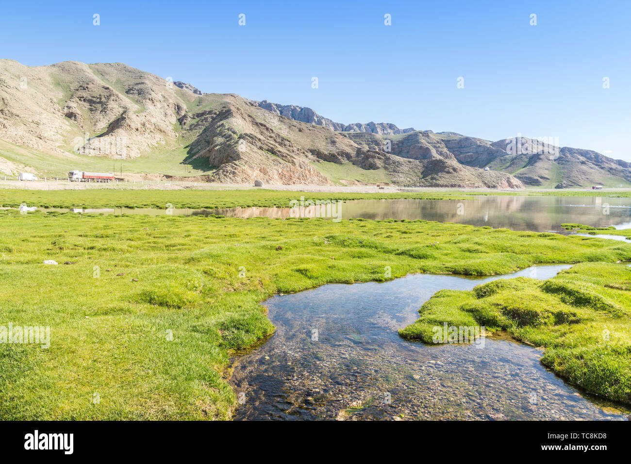 Río alpino pradera totem bajo un cielo azul y las nubes blancas en Xinjiang en verano Foto de stock
