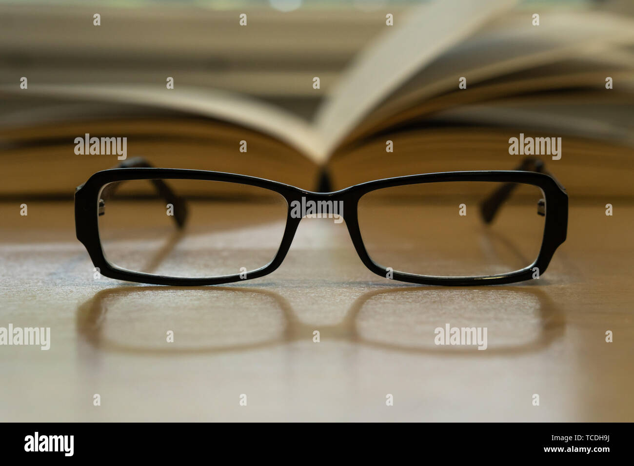 Foto de anteojos y libro abierto detrás de ellos, el concepto de lectura Foto de stock