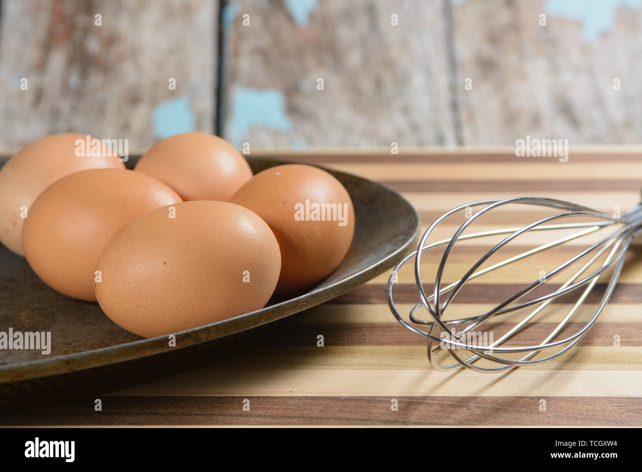 Una placa de metal con rústicos sixs huevos marrón con una batidora, y la  tabla de cortar Fotografía de stock - Alamy