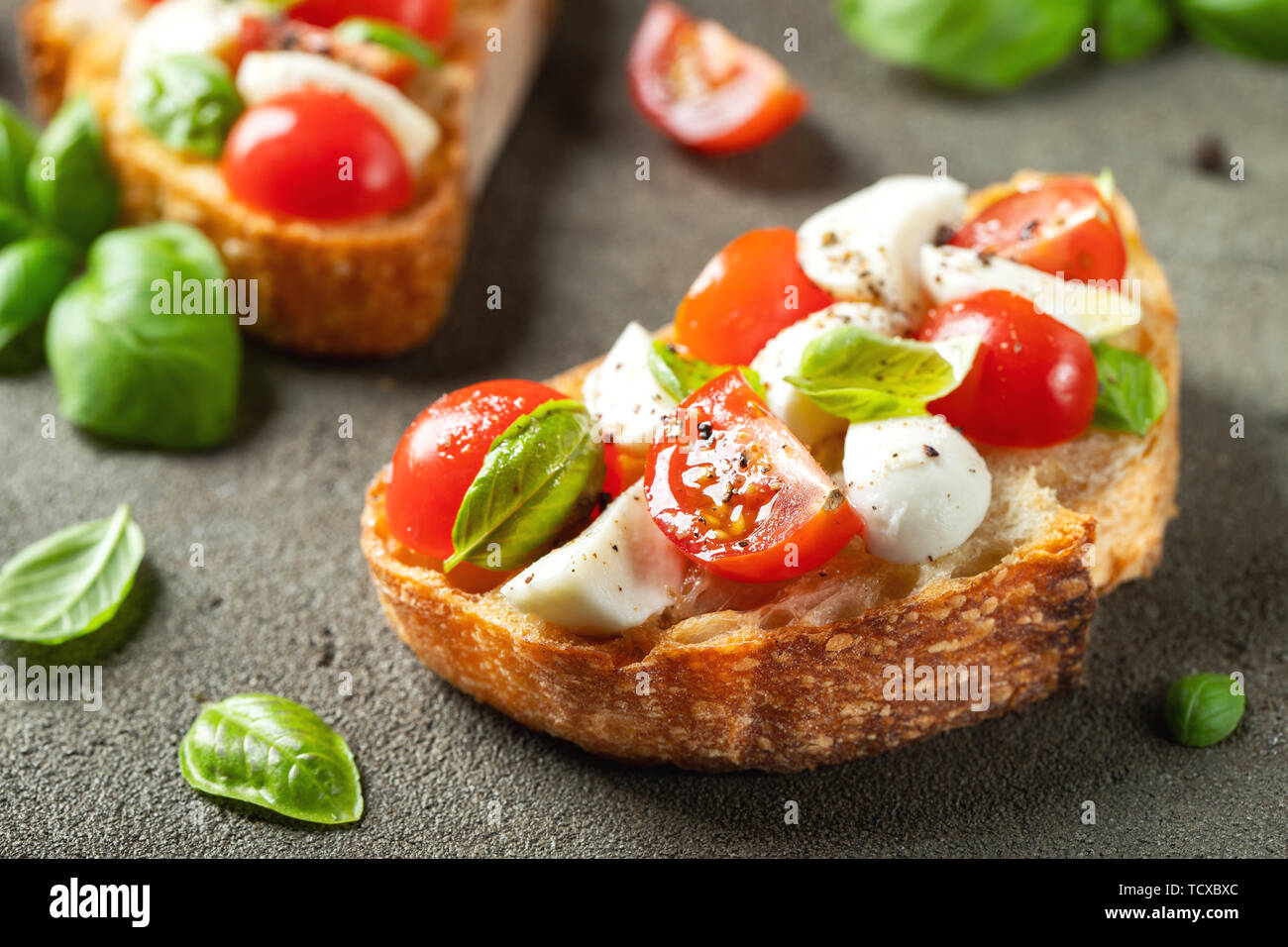 Bruschetta con tomates, queso mozzarella y albahaca sobre una antigua